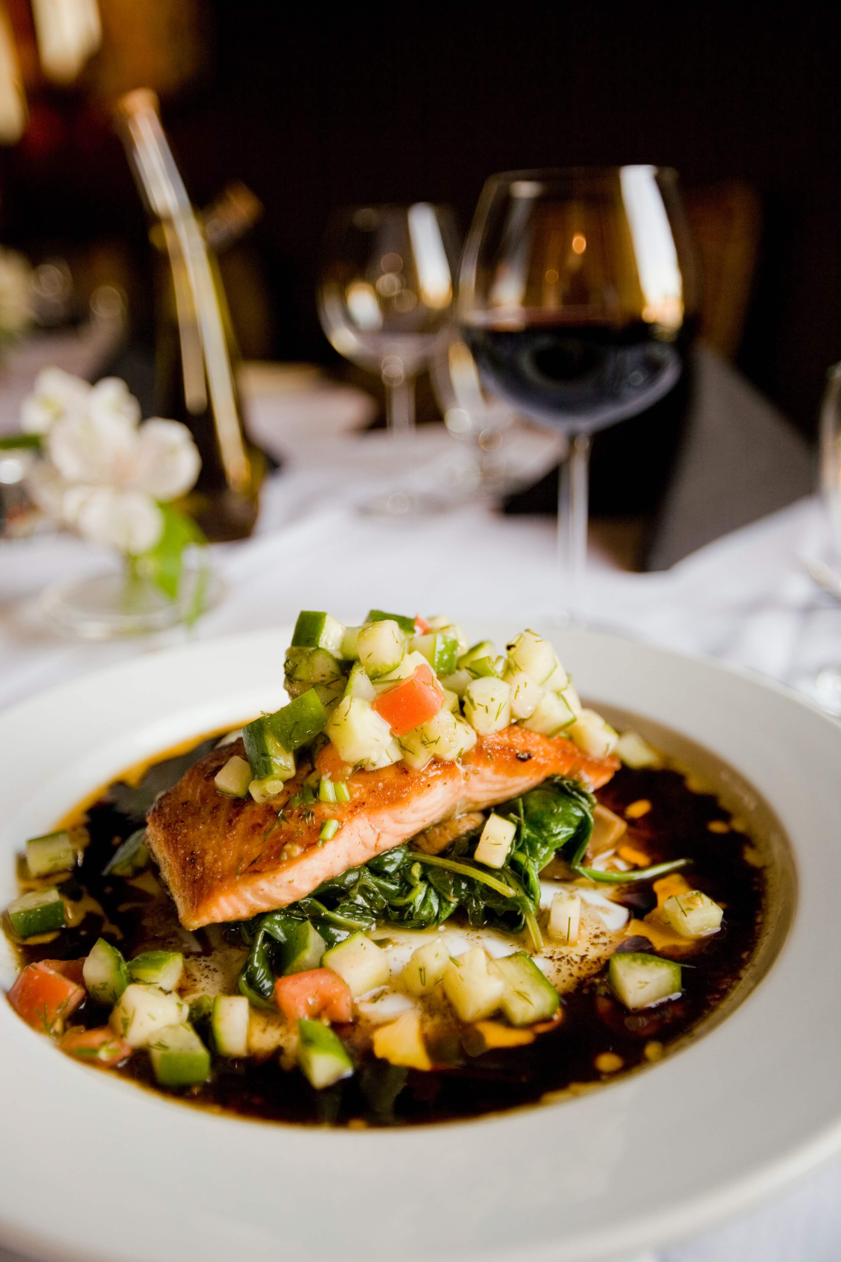 Salmon on a plate served on a table with a glowing ambience